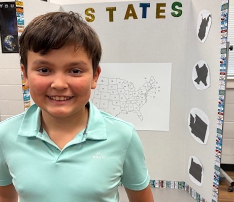 Student with their Social Studies Fair project on the United States
