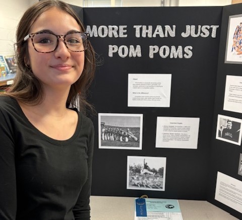 Student with their Social Studies Fair on Pom Poms
