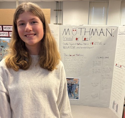 Student with their Social Studies Fair project on Mothman