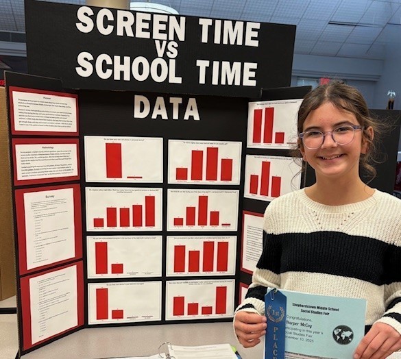 Student with their Social Studies Fair project on Screen Time.