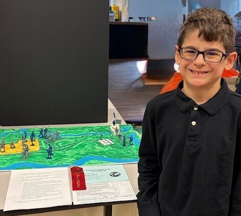 Student with their Social Studies Fair project