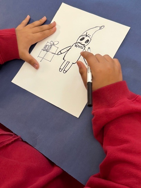 A student's drawing of an elf and present