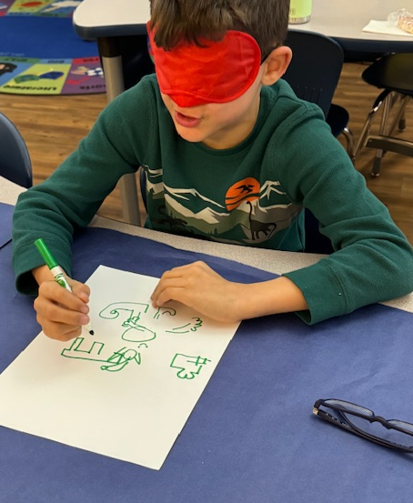 Student drawing with a blindfold on