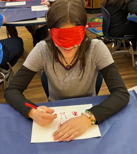 Student drawing with a blindfold on