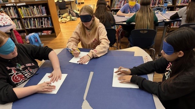 Students drawing with a blindfolds on