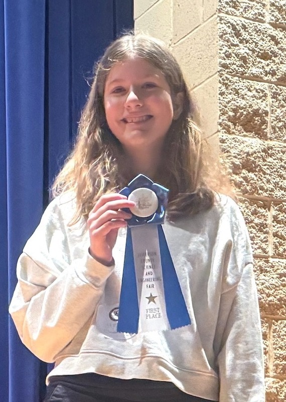 Student with winning ribbon at county Science Fair