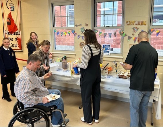 Staff filling their plates with breakfast food from FFA members.