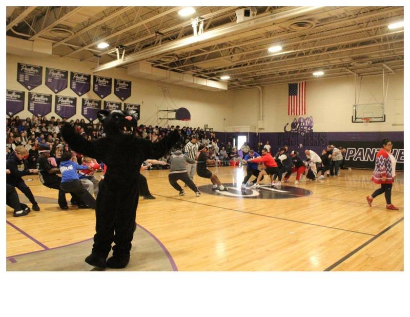 Panther mascot in front of students and staff playing tug o war