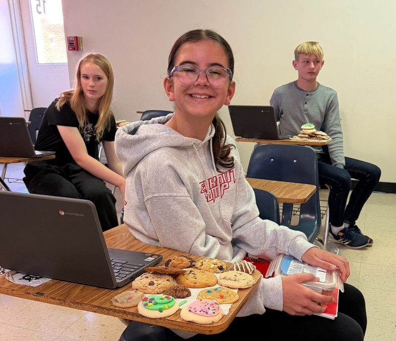 Student at a desk with a pile of cookies