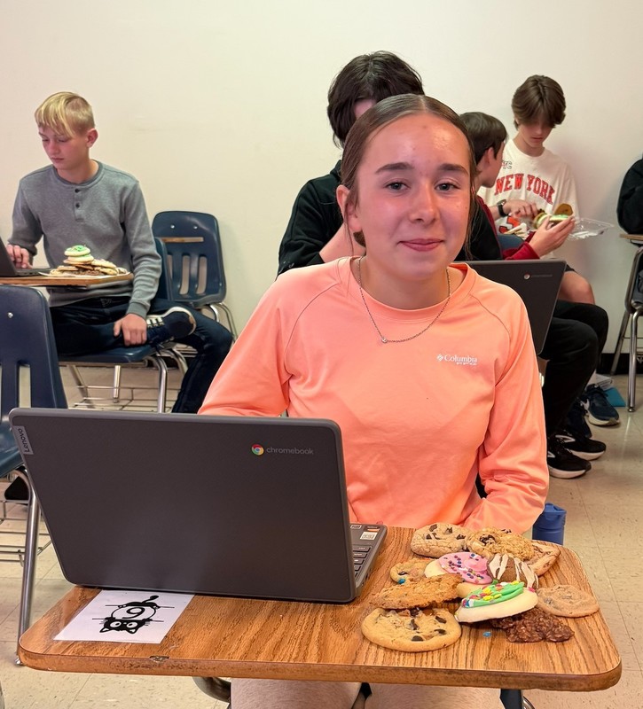 Student at a desk with a pile of cookeis