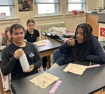 Students using mini pancakes and spoons to taste maple syrup