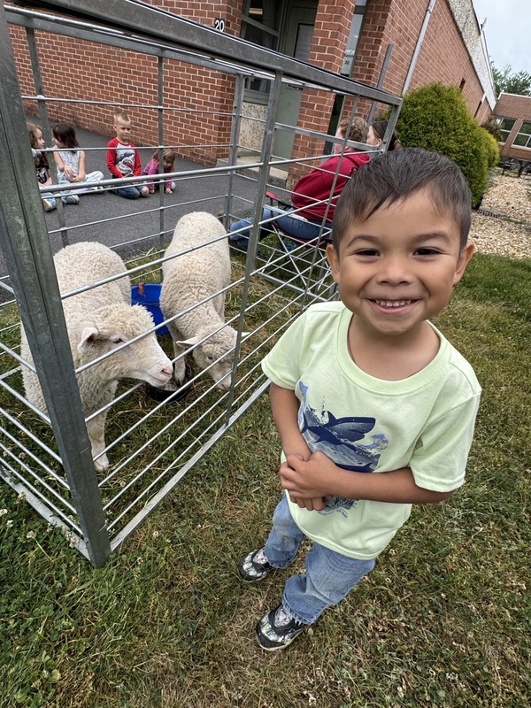 student smiling with the sheep