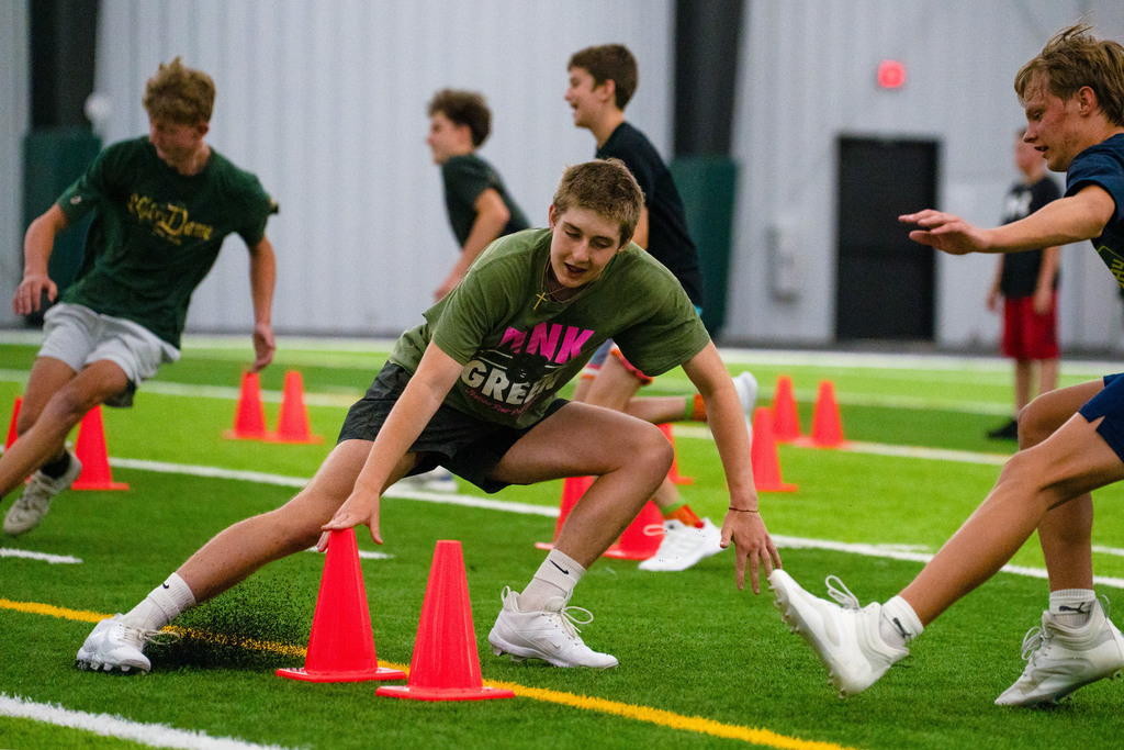 Students touching cone on field