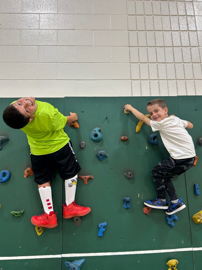 Students smiling on climbing wall