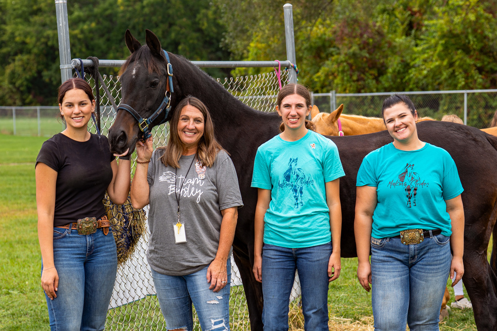 People standing next to horse