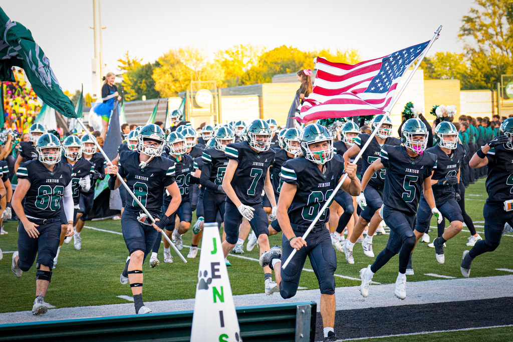 Football players running on field