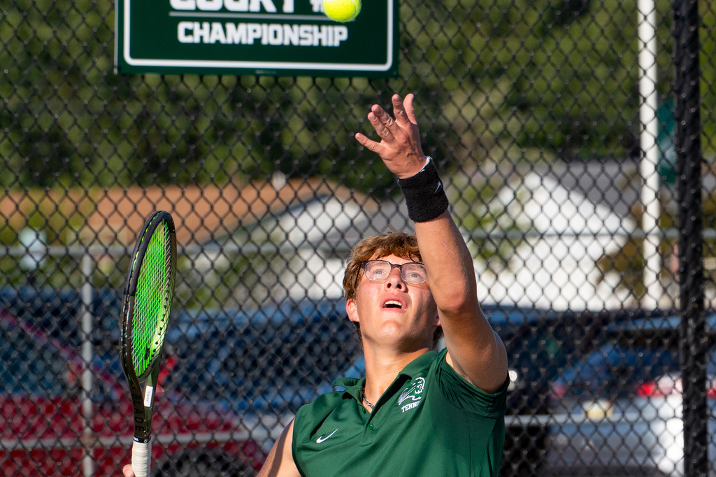Tennis player throwing ball in air