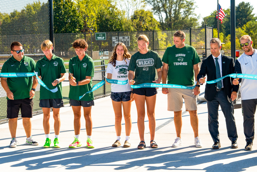 Tennis players cutting ribbon