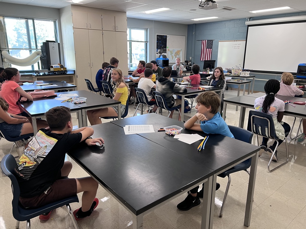 J-Stem Students sitting at tables creating binary code bracelets