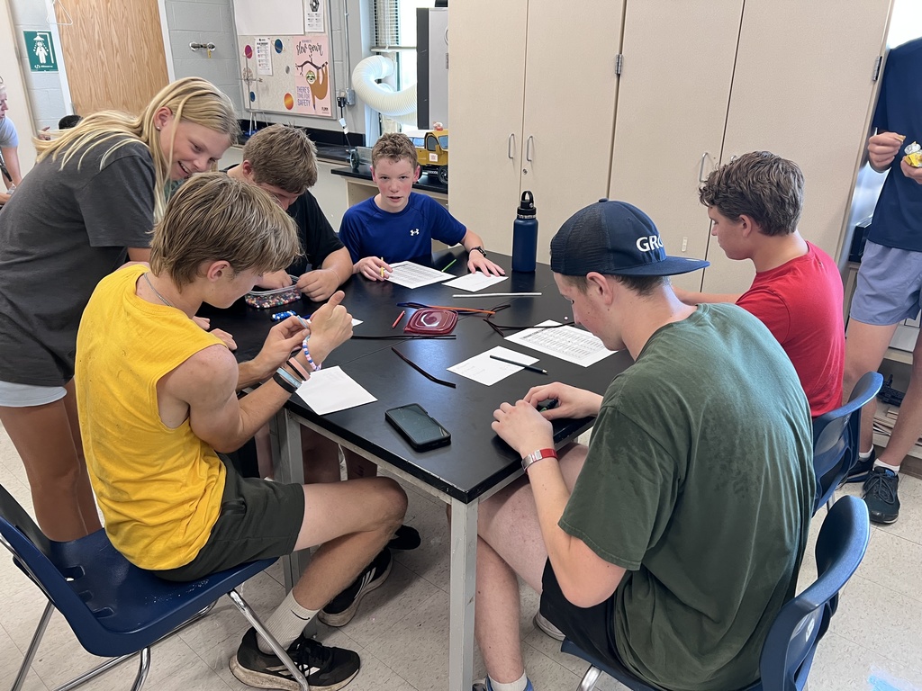 J-Stem Students sitting at tables creating binary code bracelets