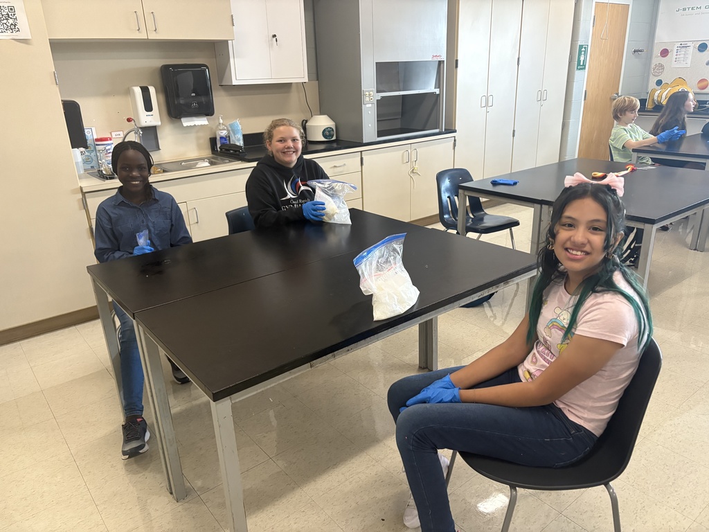 Three students sitting at a table making Ice Cream