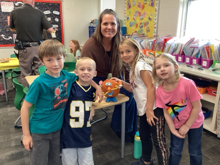 Students and staff with decorated pumpkin