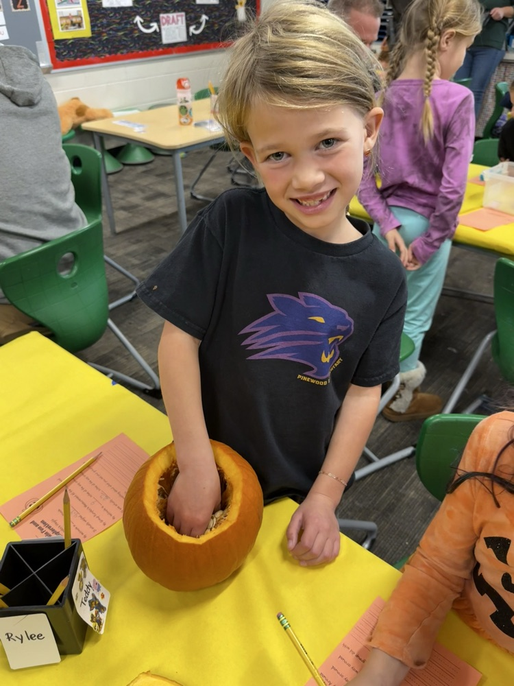 student gutting pumpkin