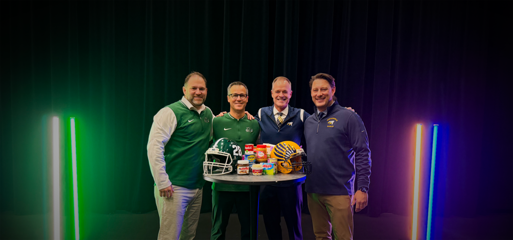 Jenison and Hudsonville admin members standing around table