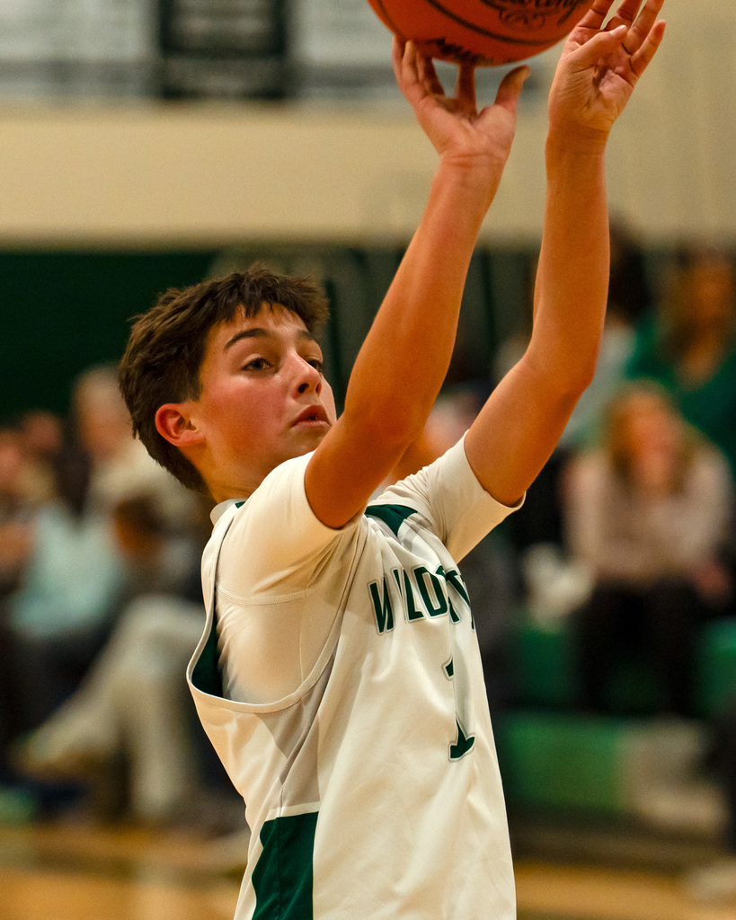 Junior high basketball player shooting basketball