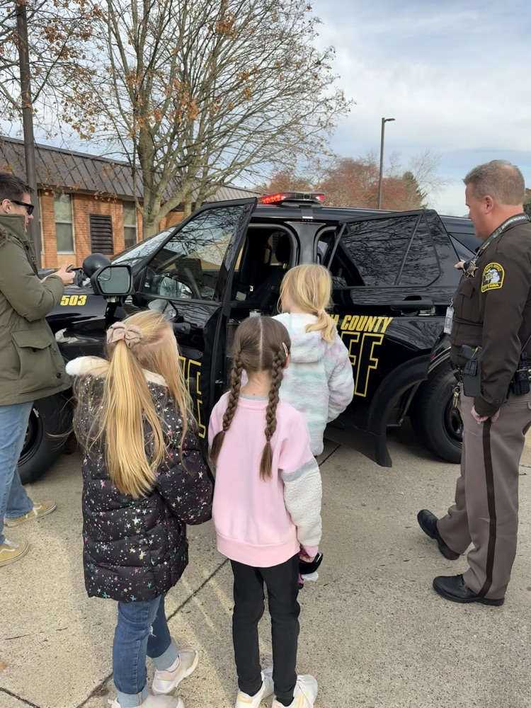 students looking at police car