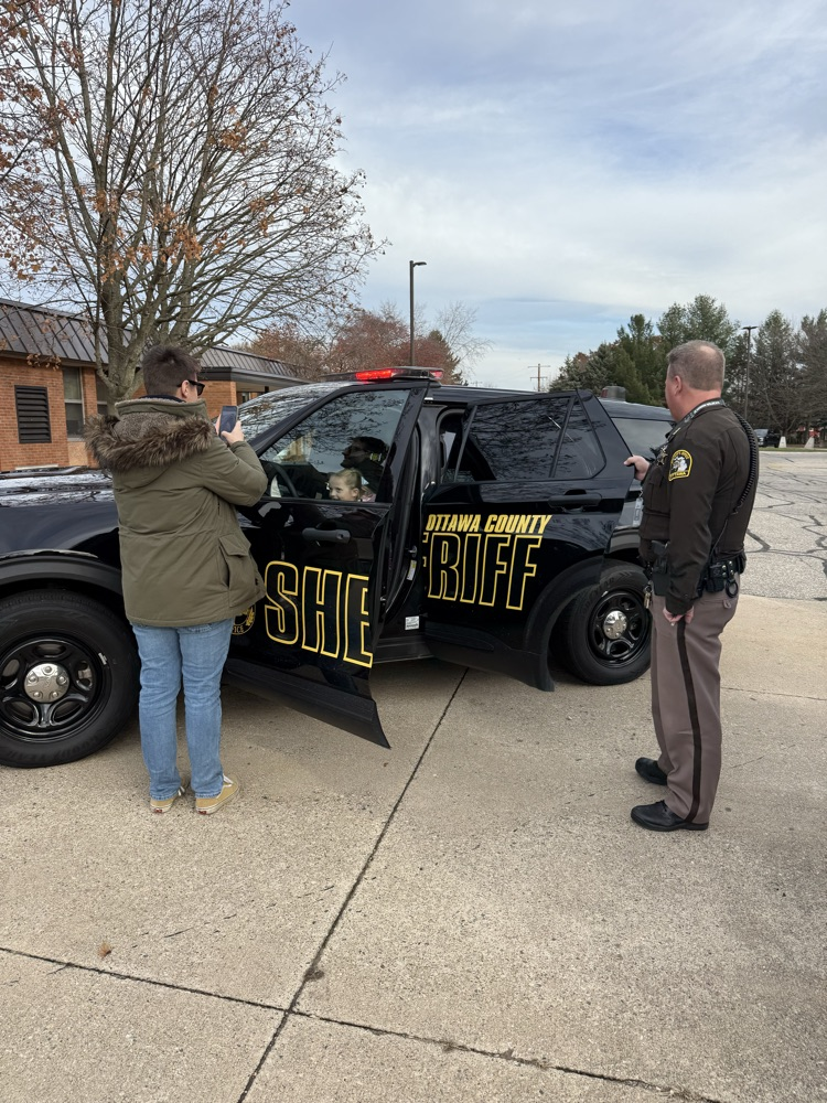 students looking at police car
