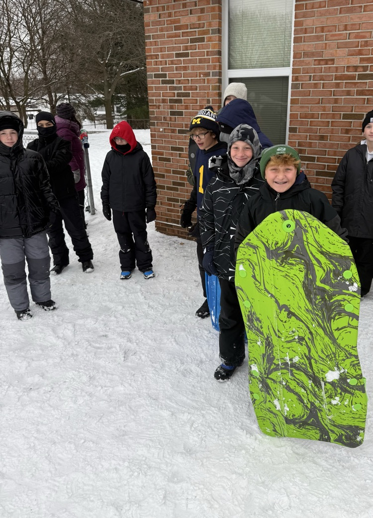 students smiling with sleds 