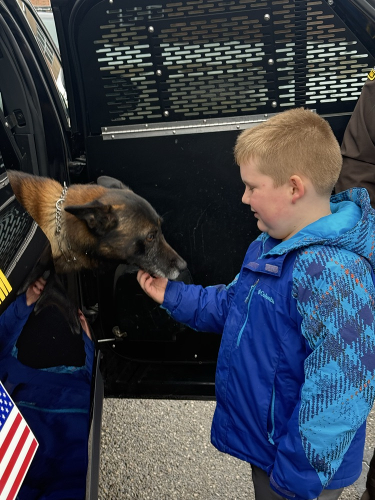 student petting police canine