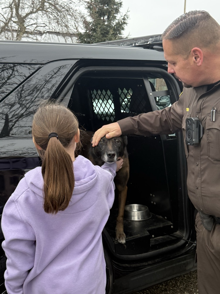 student petting police canine