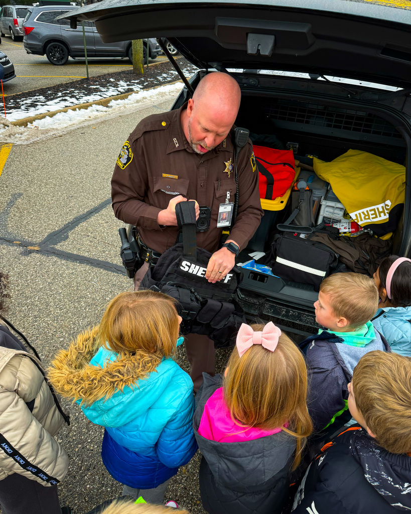 Police officer showing students his gear