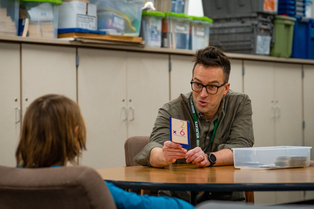 Watch Dog dad smiling and working with students