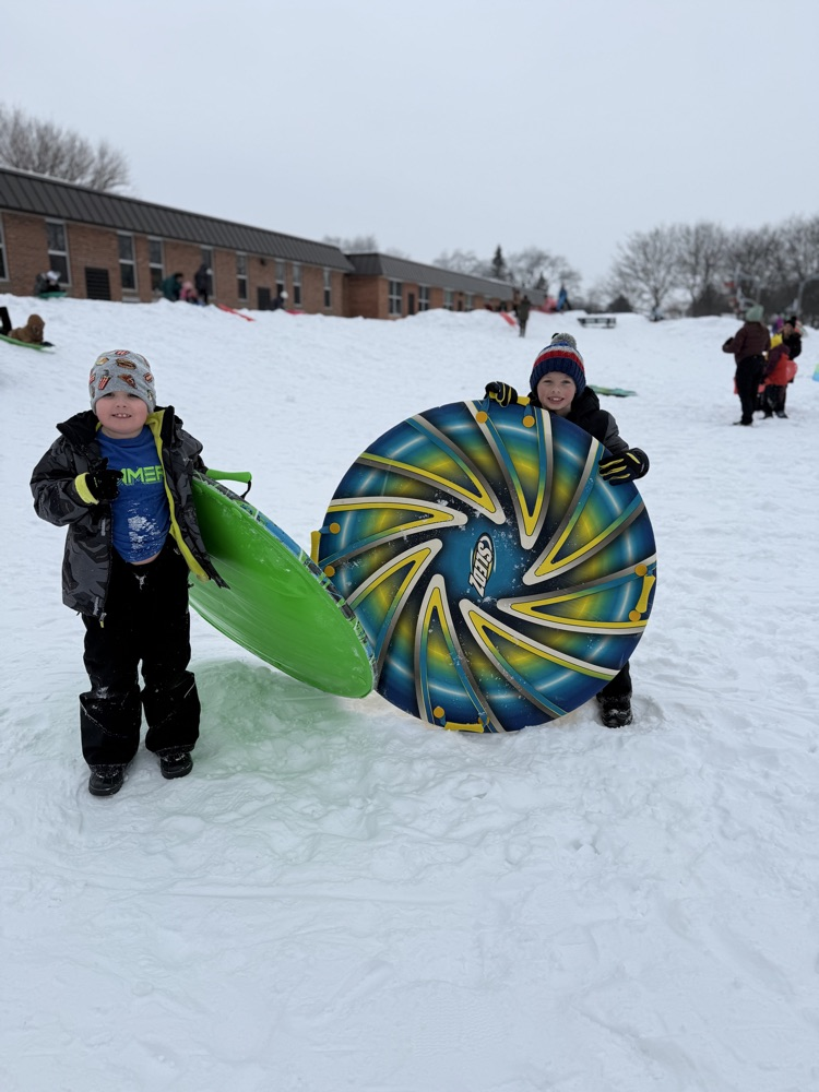 students posing with sleds