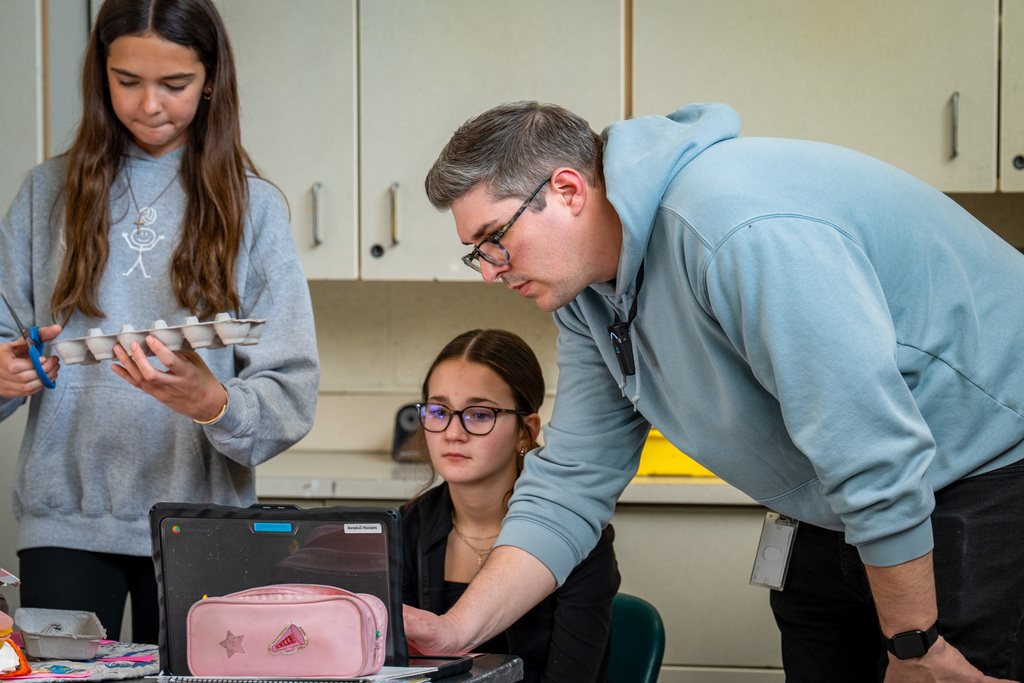 Art teacher helping students with project