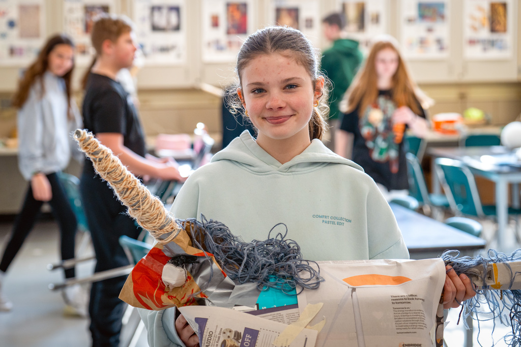 Student posing with art project