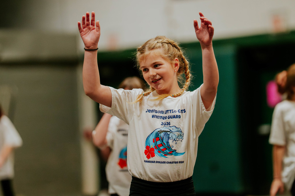 Elementary student with hands in air