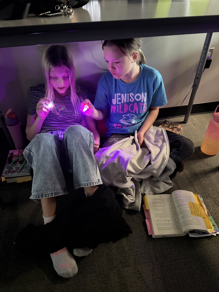 Kids reading with tiny finger flashlights. 