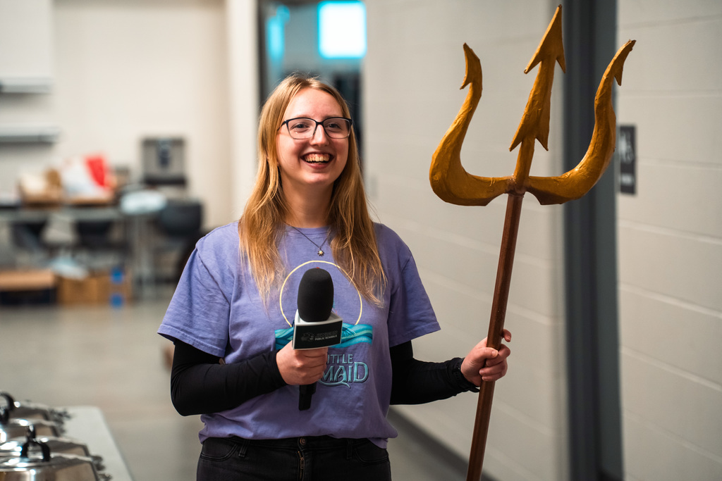 Theater student smiling behind the scenes