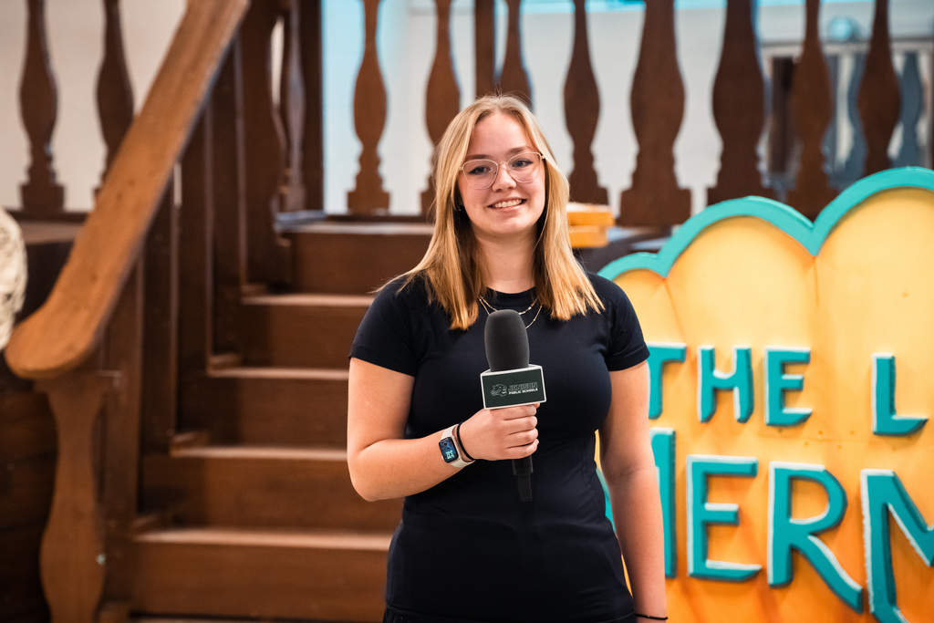 Theater student smiling near set