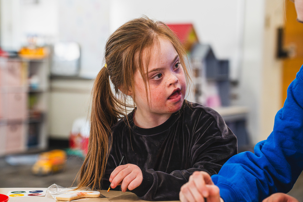 Students at desk with teacher