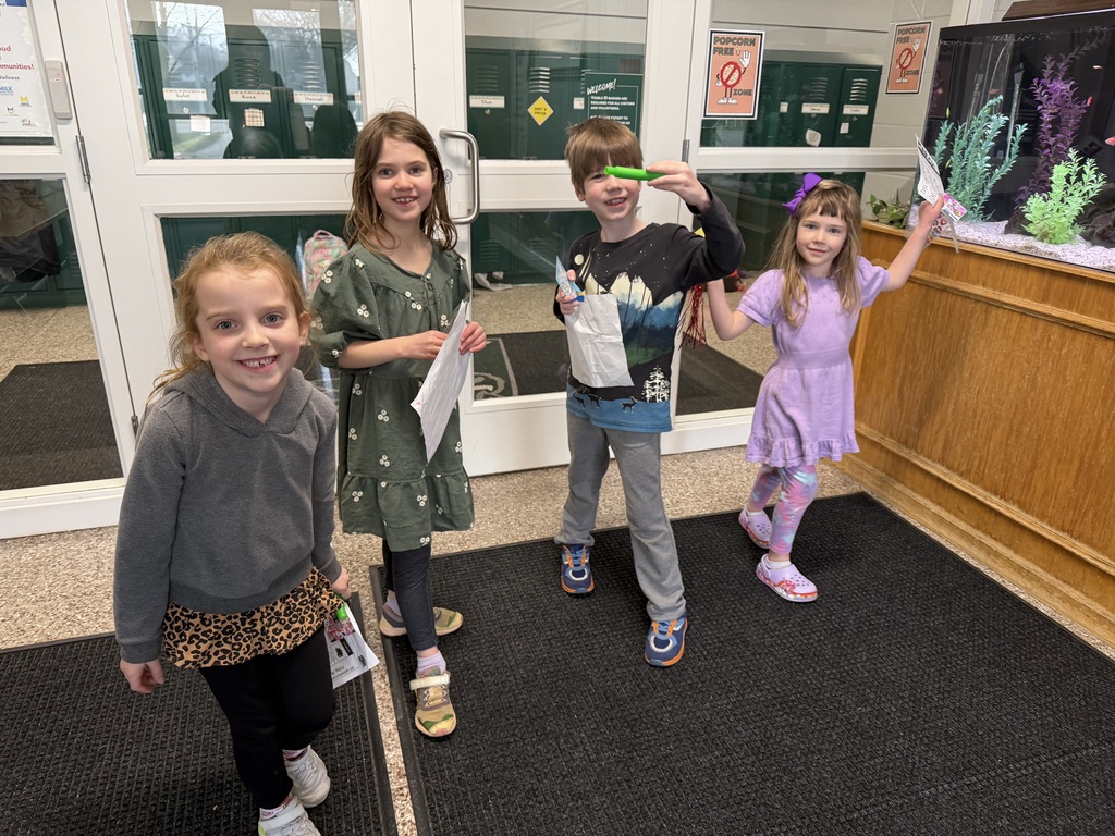Students smile after completing a Reading Month activity throughout the halls of JIA.