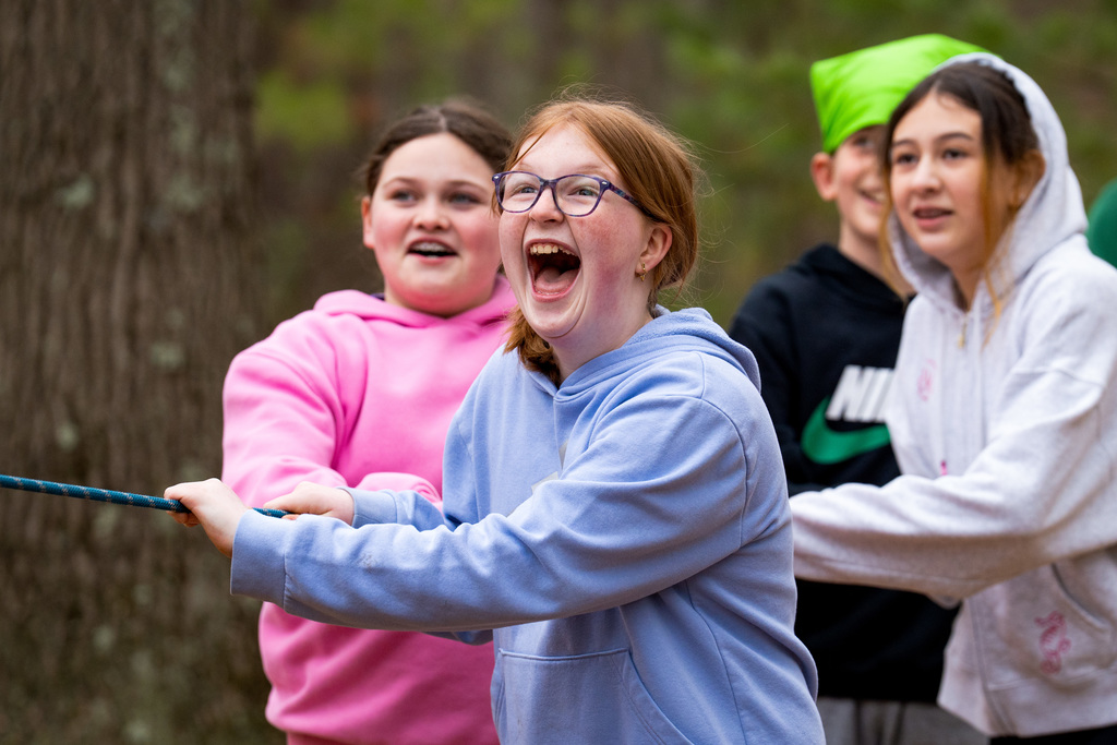 Students smiling while holding on to ropes