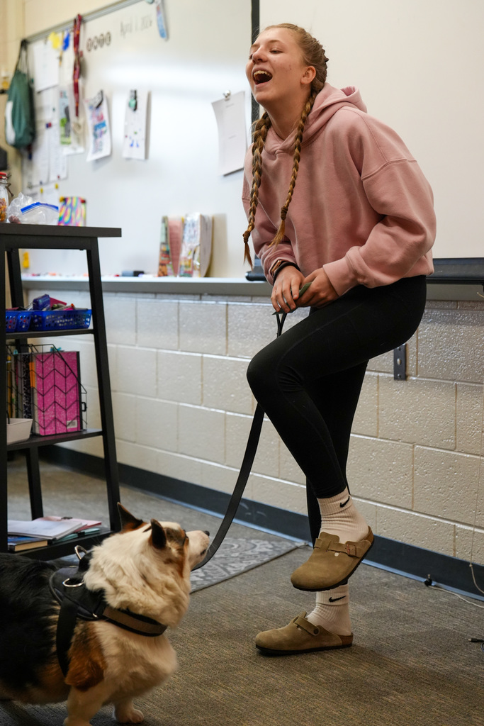 Student laughing with their dog
