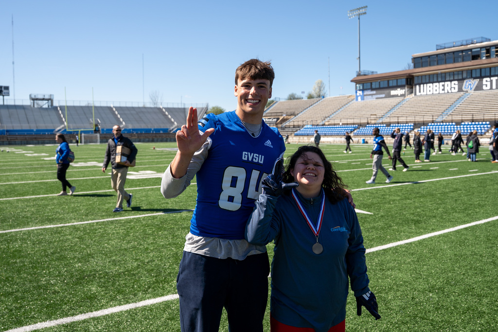 Jenison Unified student posing with football player on field