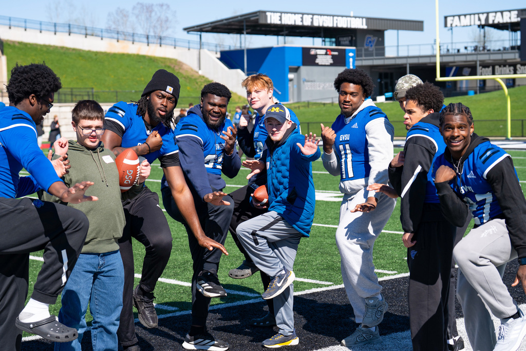 Unified students posing with football team