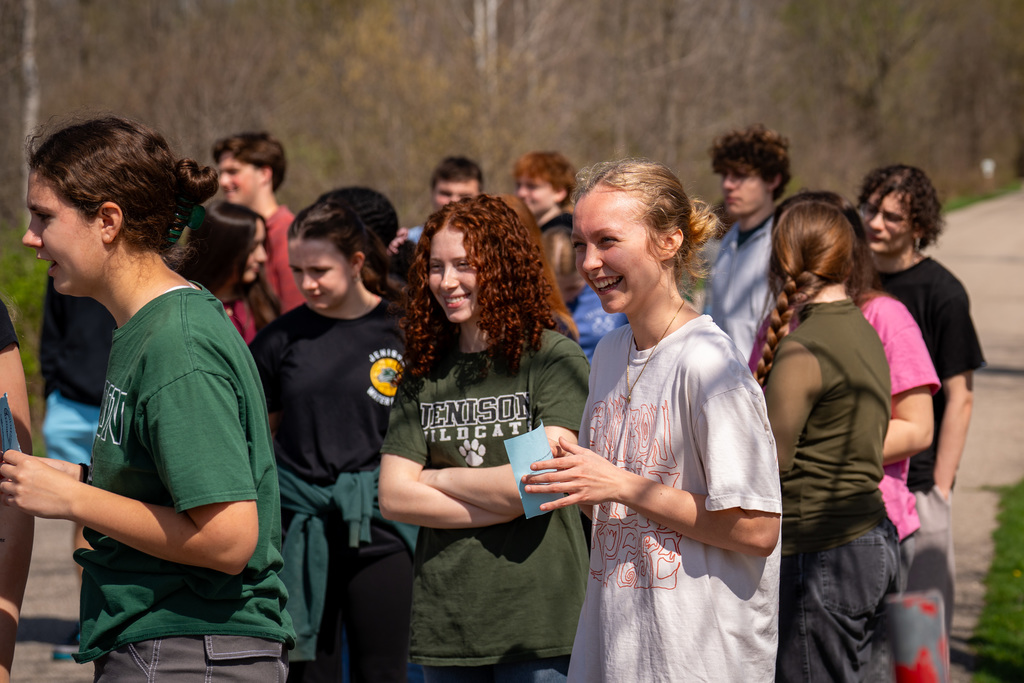 High school students smiling as they wait for elementary students